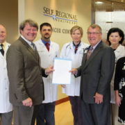 Pictured from left are: Dr. John Funke, radiation oncologist; Rep. Pinson; Dr. Brian Hunis, medical oncologist; Dr. Joanna Sadurski, medical oncologist; Pfeiffer; Dr. Lena Vician, medical oncologist; and Kendra Keeney, Administrative Director of Cardiovascular and Cancer Services at Self Regional.