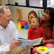 Neonatologist Terry Marshall, M.D., reads a story to his former patient, Jo'Noah, while his mother, Theresa Peterson, holds him. Jo'Noah was born at 23 weeks at Self Regional Medical Center and weighed just 1 lb. 6 ounces at birth. The little boy, who lives in Greenwood, is a natural jokester, according to his mom, and is growing and developing at a rapid pace.