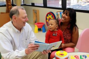 Neonatologist Terry Marshall, M.D., reads a story to his former patient, Jo'Noah, while his mother, Theresa Peterson, holds him. Jo'Noah was born at 23 weeks at Self Regional Medical Center and weighed just 1 lb. 6 ounces at birth. The little boy, who lives in Greenwood, is a natural jokester, according to his mom, and is growing and developing at a rapid pace.