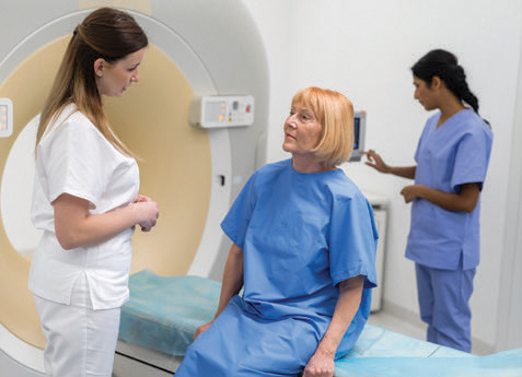 Doctor speaks to patient with MRI machine in the background