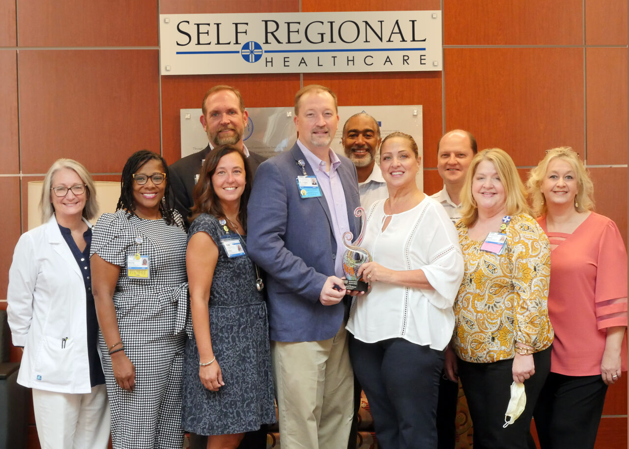 Self Regional Healthcare team members posing together with an award at a recognition event.