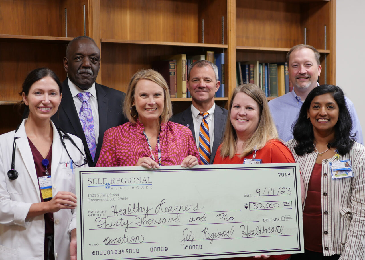 Self Regional Healthcare staff present a check for 30,000 dollars to Healthy Learners