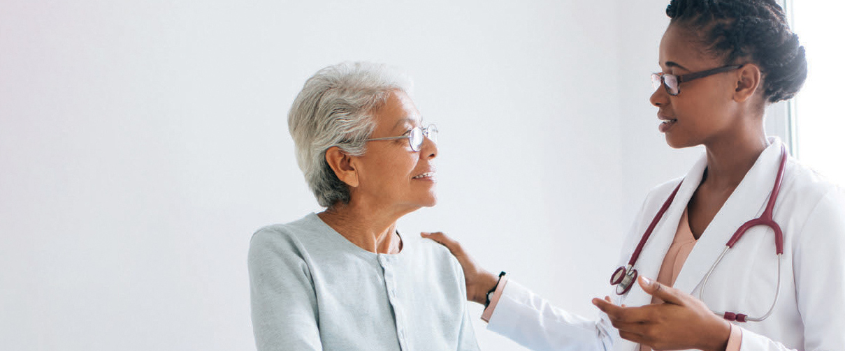 Two smiling women in discussion, a patient and her doctor.