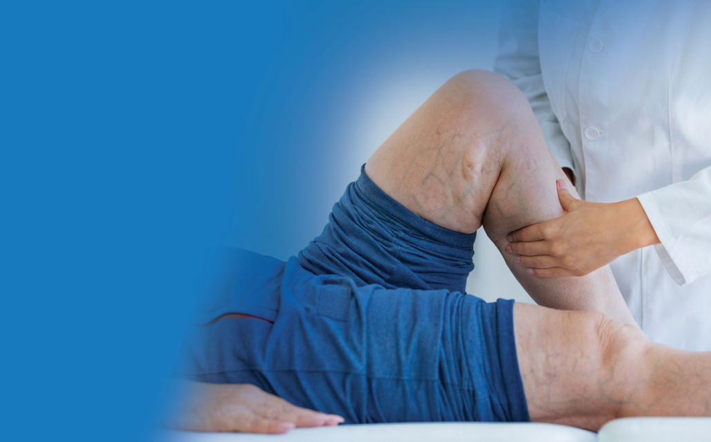 Doctor examining patient's knee injury during physical examination.