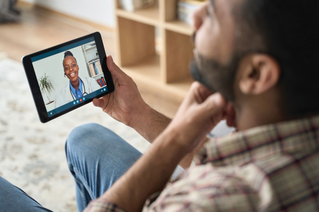 Man on video call with healthcare provider on tablet device