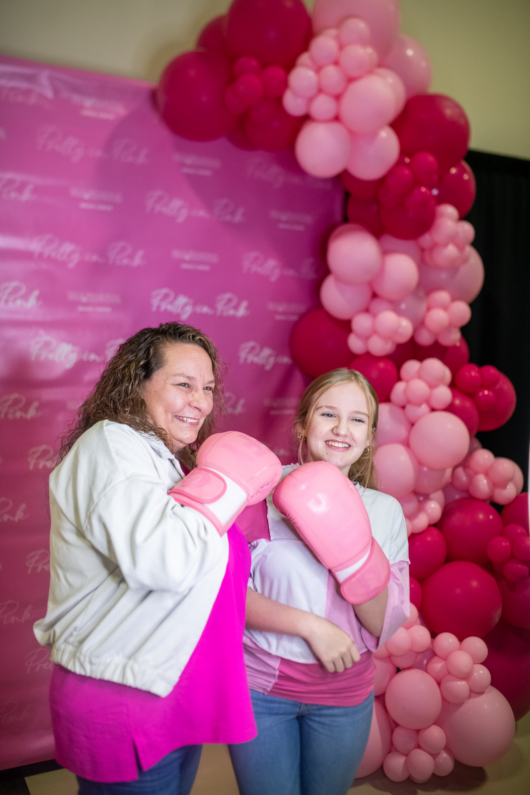 Women in pink boxing gloves at breast cancer awareness event