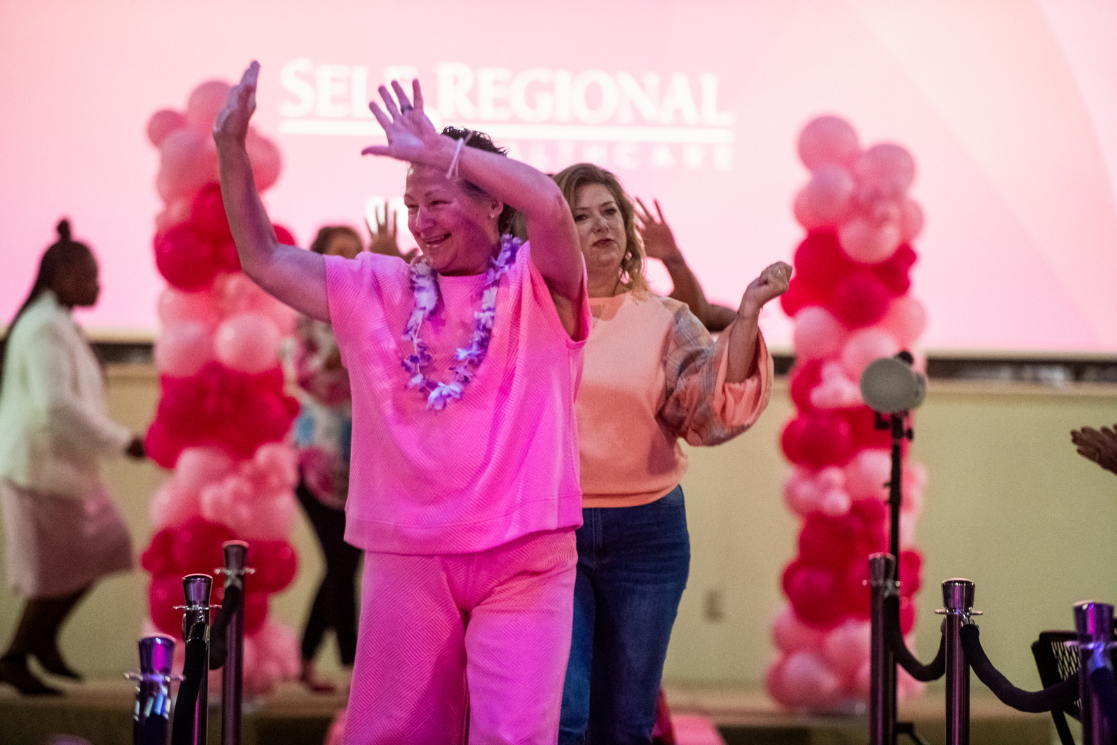 Person in pink outfit dancing at healthcare event celebration