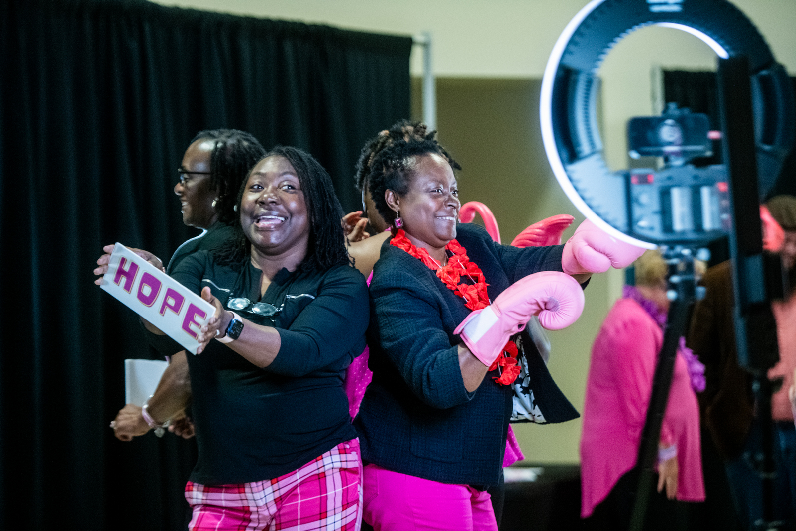 Women in pink boxing gloves at breast cancer awareness event