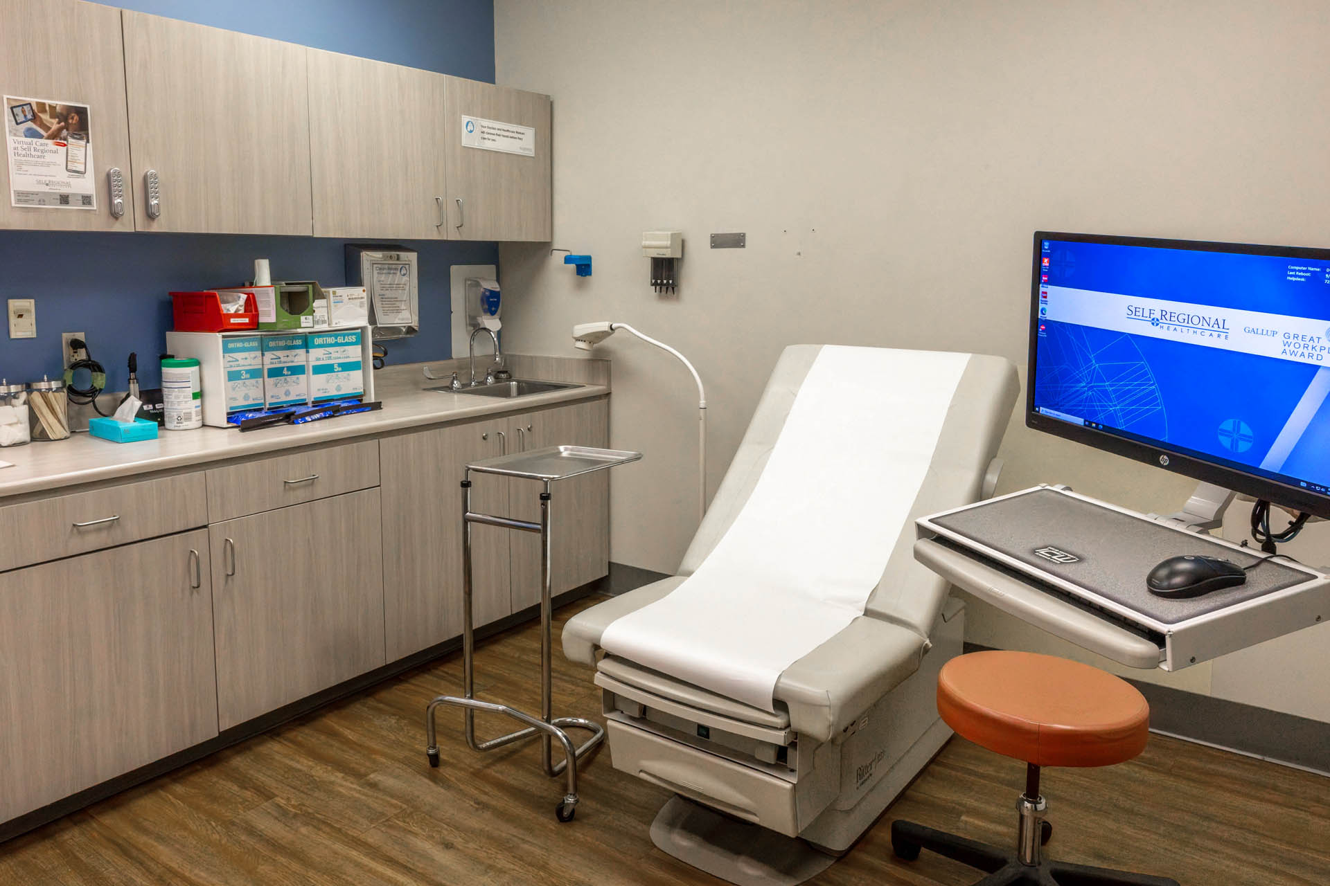 Medical examination room with patient chair and computer workstation