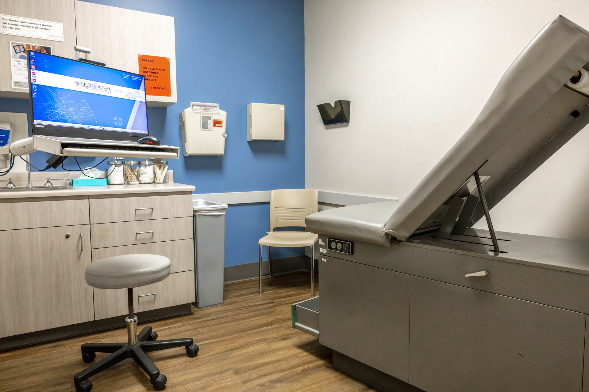 Medical examination room with diagnostic equipment and workstation