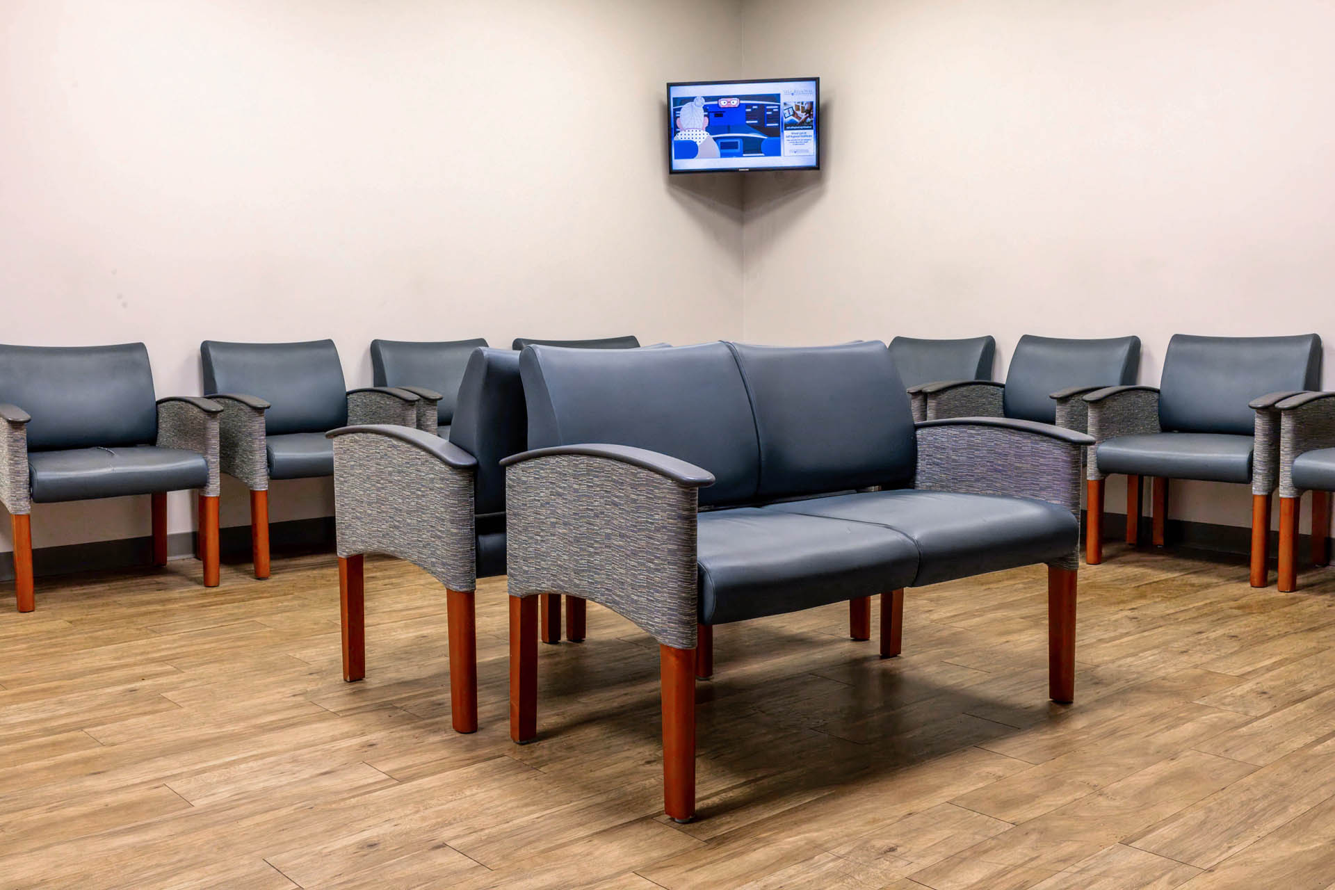 Waiting room with upholstered seating and television display