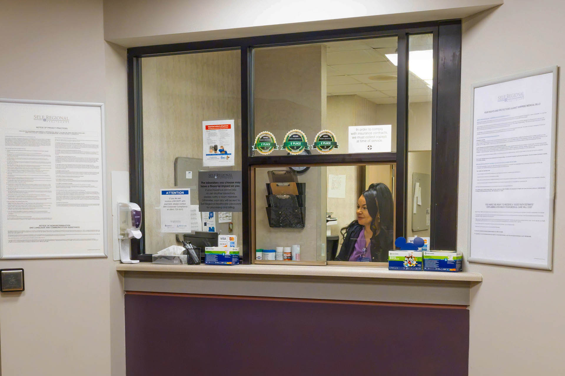 Self Regional Healthcare reception window with staff member at desk