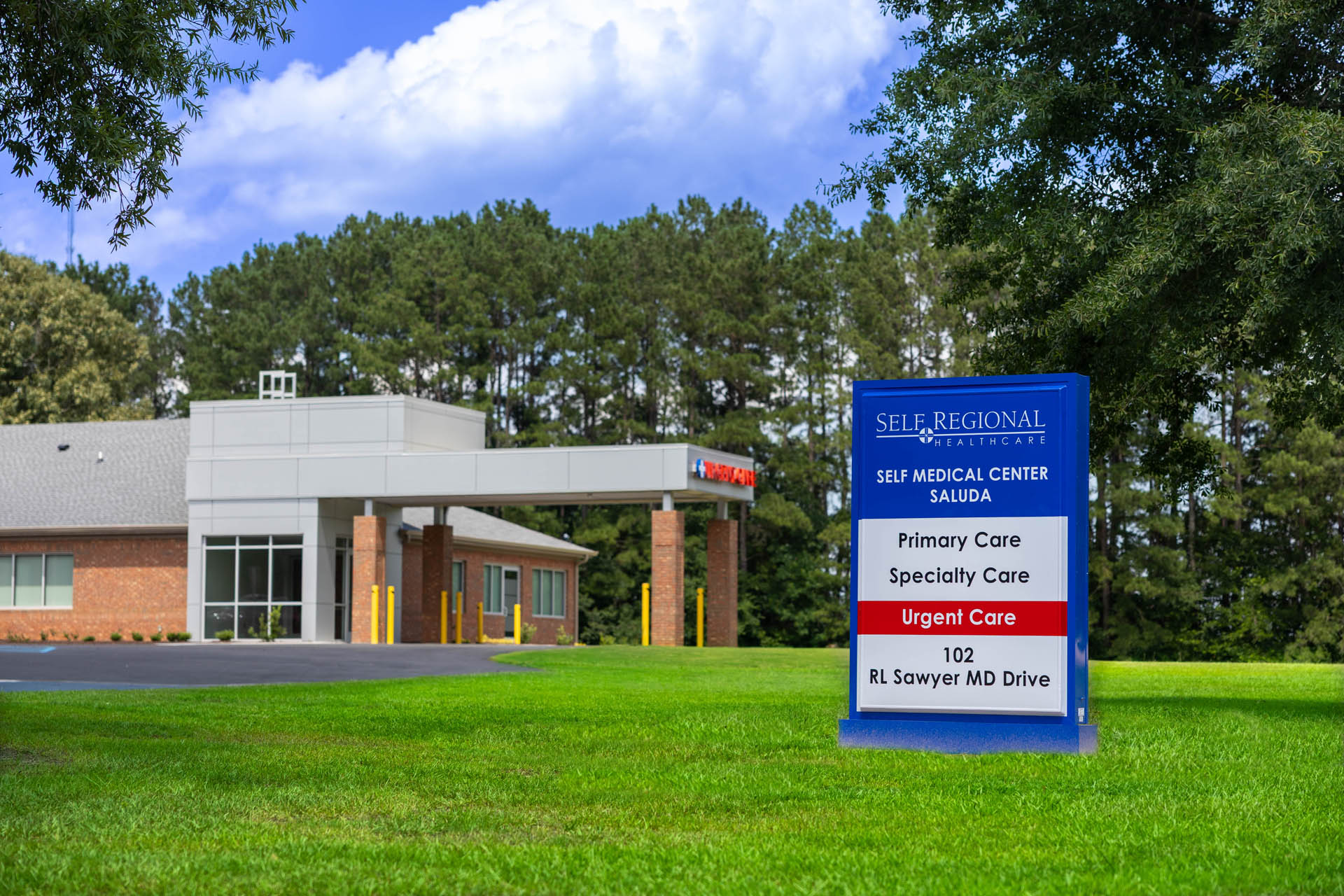 Exterior view of Self Medical Center Saluda with monument sign listing Primary Care, Specialty Care, and Urgent Care services