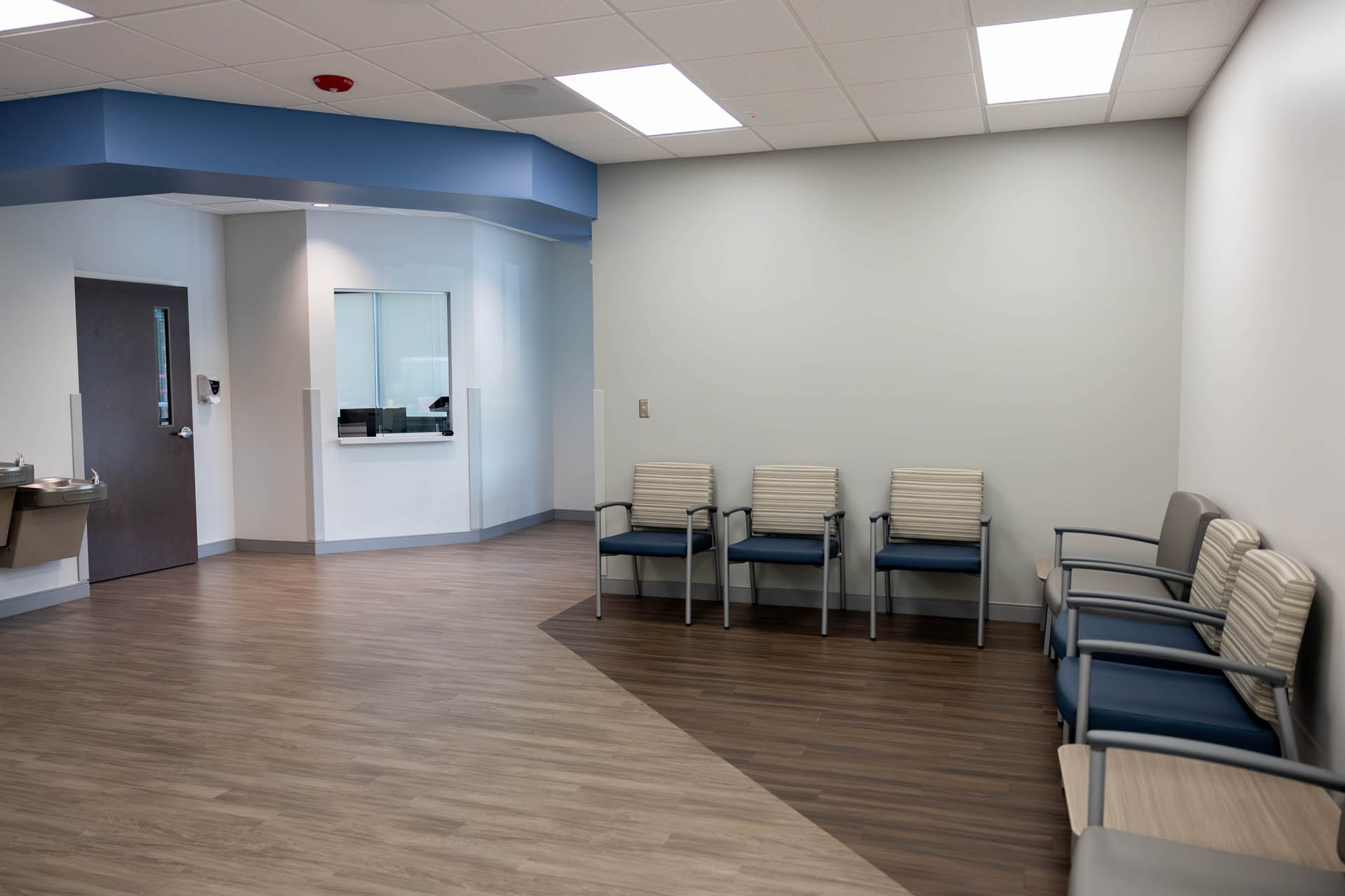 Second view of the Urgent Care Saluda waiting room showing reception window and patient seating along the walls