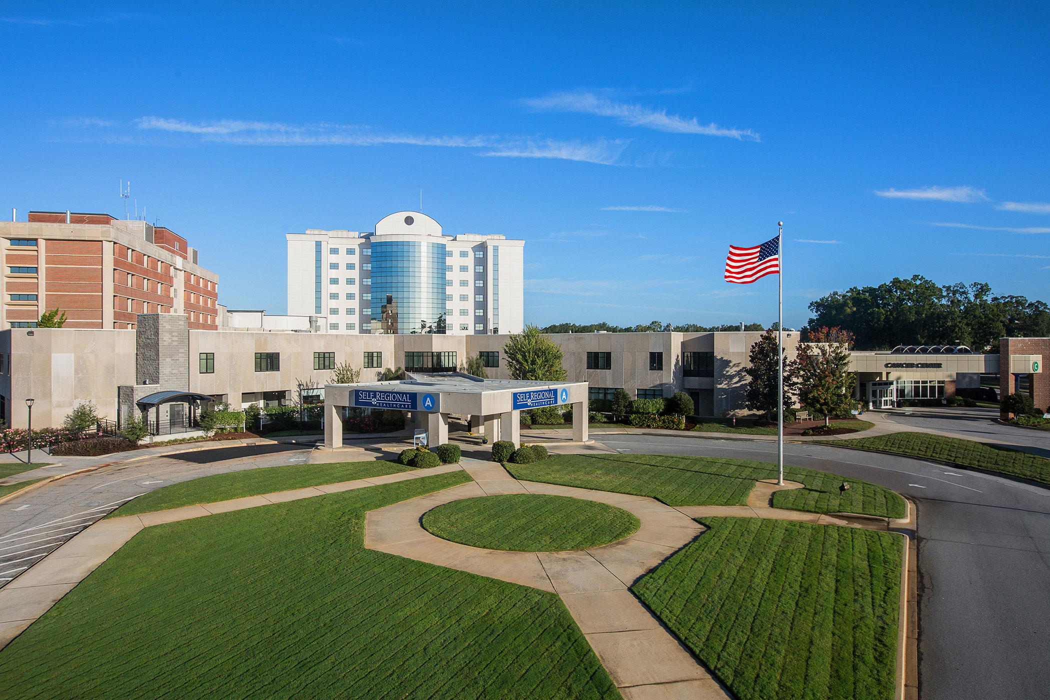 Self Regional Healthcare hospital entrance with circular landscaping and American flag
